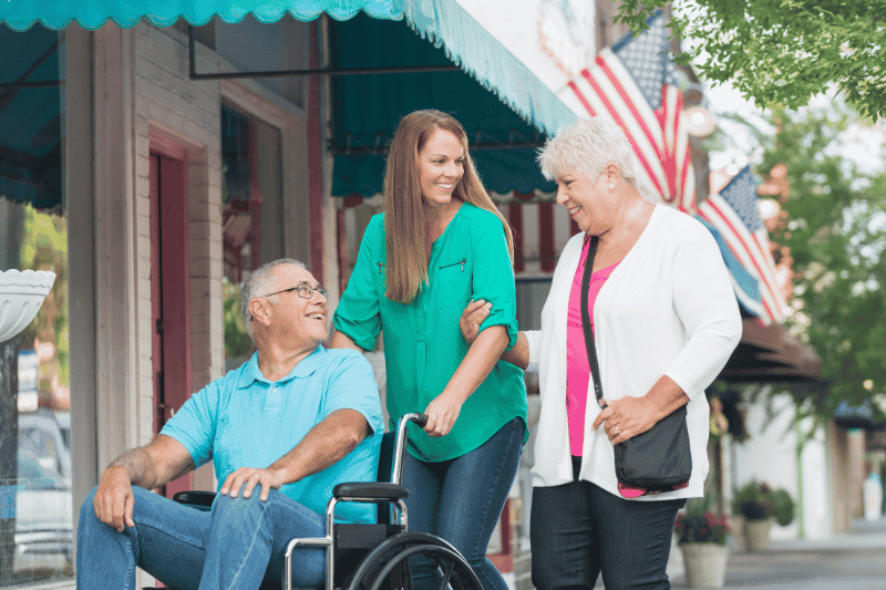 senior in wheelchair smiling at family