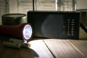 A flashlight and battery-powered radio symbolize ways to help seniors prepare for power outages.