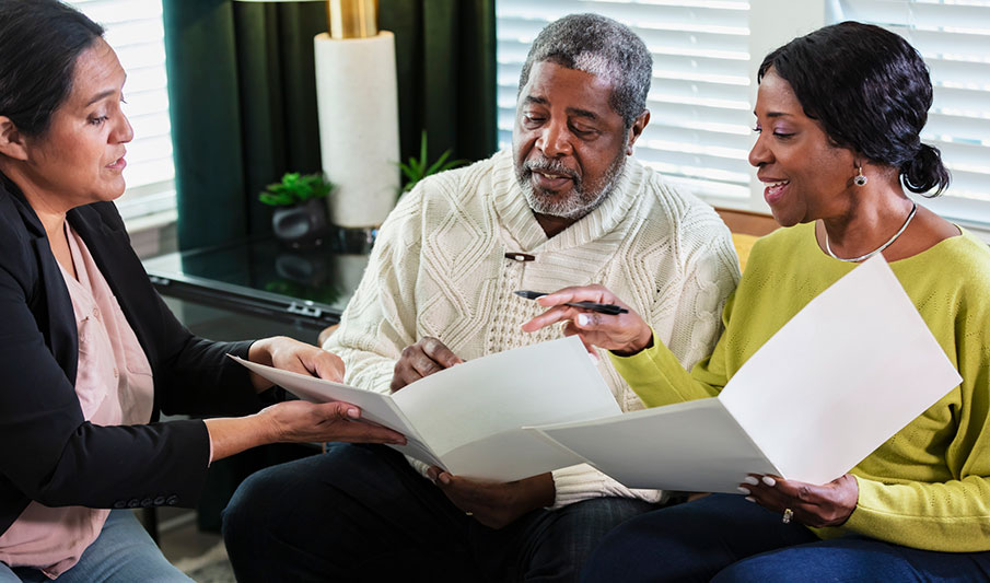 An older couple reviews a Parkinson’s care plan with a care professional.